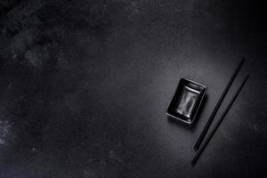 Wooden sushi sticks on a dark concrete background photo