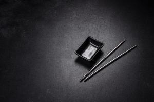 Wooden sushi sticks on a dark concrete background photo