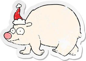 distressed sticker cartoon of a walking polar bear wearing santa hat vector