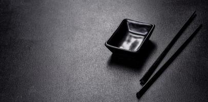 Wooden sushi sticks on a dark concrete background photo