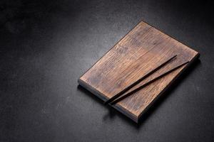 Wooden sushi sticks on a dark concrete background photo