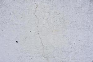 Texture of a concrete wall with cracks and scratches which can be used as a background photo