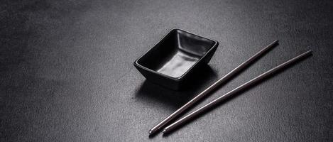 Wooden sushi sticks on a dark concrete background photo