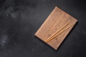 Wooden sushi sticks on a dark concrete background photo