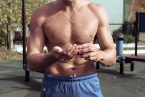 vista recortada de un hombre deportivo usando un aceite de calentamiento muscular foto