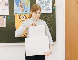 young beautiful art teacher explains children how to draw a picture. photo