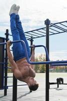 Toned man workout on parallel bars. photo