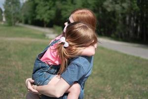 young ginger haired woman calming down her little daughter. photo