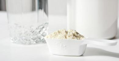 Collagen or protein peptides in powder on white table. protein powder for making whey drink or collagen cocktail for joints and beautiful skin photo