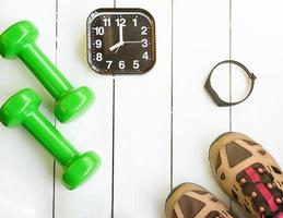 Time for exercising concept. alarm clock and dumbbells photo