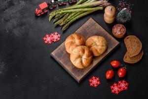 panecillos redondos crujientes, conocidos como panecillos kaiser o viena en una mesa navideña foto