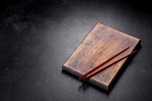 Wooden sushi sticks on a dark concrete background photo