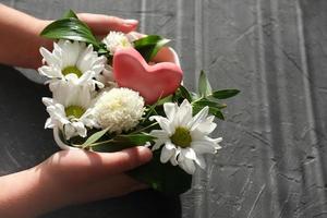 hands holding red heart and flowers photo