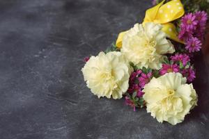 bright bouquet with yellow carnations on grey background photo