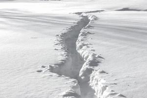 un camino en alta ventisquero. banco de nieve y un sendero foto