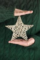 manos femeninas sosteniendo eco estrella de navidad. foto