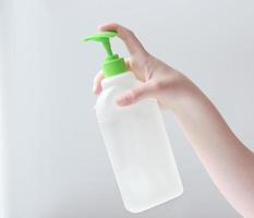 young woman's Hand holding white sanitaizer bottle photo