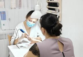 Manicurist and a client during manicure. photo