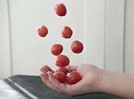 flying tomatoes over woman's hand. photo