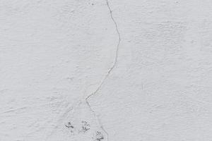 Texture of a concrete wall with cracks and scratches which can be used as a background photo