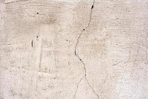 Texture of a concrete wall with cracks and scratches which can be used as a background photo