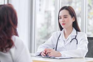 Asian professional  female doctor suggests healthcare solution to her patient elderly in examination room at hospital. photo