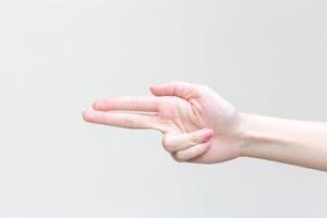 Beautiful female hand shows heart symbol as victory sign in manicure concept. photo