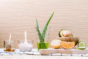 Homemade skin care and body scrub with natural ingredients avocado ,aloe vera ,lemon,cucumber ,orange ,apple, lime and honey set up on on wooden background..