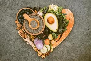 Heart shape of ketogenic low carbs diet concept. Ingredients for healthy foods selection on dark stone background. Balanced healthy ingredients of unsaturated fats for the heart and blood vessels. photo