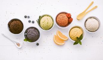 Various of ice cream flavor ball blueberry ,lime ,pistachio ,almond ,orange ,chocolate and vanilla set up on white wooden background . Summer and Sweet menu concept. photo