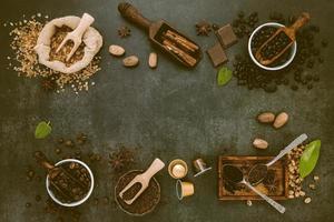 Coffee background with various of roasted coffee beans and flavourful ingredients for make tasty coffee setup on dark stone background. photo