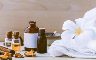 ingredientes naturales de spa y botella de aceite de extracto de hierbas para medicina alternativa y aromaterapia. tema de spa tailandés con terapeuta ayurvédico sobre fondo de madera en mal estado. foto