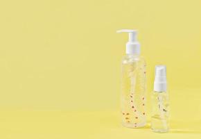 unbranded bottles of gel for body and face skincare. light summer care for dry skin. sensitive skin treatment. yellow background photo