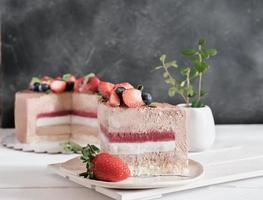 a piece of cake with mousse filling and strawberry jelly. low sugar homemade cake photo