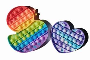 children pop it toys isolated, duck and heart shaped fidgets rainbow colored. multicolor silicone bubbles toys for relax and antistress. tik tok trend. photo