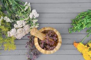 herbs for herbal tea. mortar and pestle on grey rustic table photo