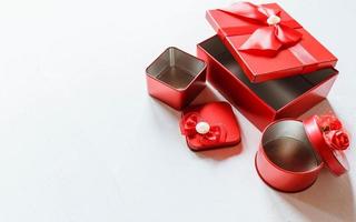 caja de regalo roja abierta sobre una mesa de madera blanca foto