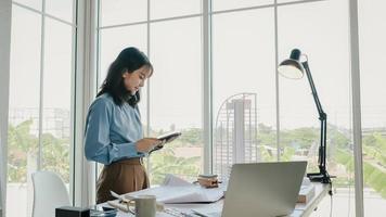 enfoque selectivo, arquitecta o ingeniera asiática dibujando el diseño del interior del edificio usando una tableta. una arquitecta o ingeniera asiática se sienta y analiza, diseña proyectos en la oficina. foto