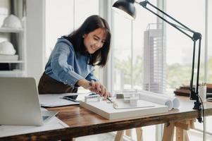 Selective focus, Asian female architect or engineer Currently considering materials for designing modern condominiums. Asian female architect or engineer Sit and analyze, design projects in the office photo