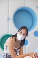 Close-up woman wearing face mask because Air pollution, virus epidemic, flu. Young elegant happy Asian woman put on protective photo