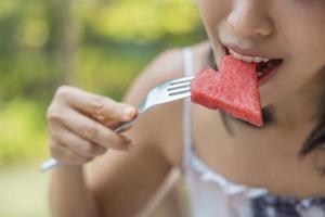 Close up of woman raised a plate of eat fruit with watermelon and passion fruit. Girl enjoy fruit for lunch, wellbeing diet concept. Concept of health photo