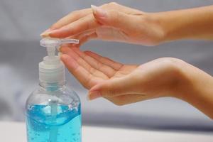 Woman or lady pressing alcohol gel on her hand. Health, treatment, protect and hygiene concept. photo