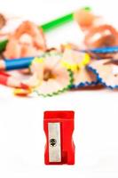 Red pencil sharpener with color shavings pencils. Vertical image. photo