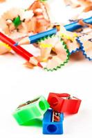 Red, green and blue pencil sharpener with color shavings pencils. Vertical image. photo