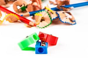 Red, green and blue pencil sharpener with color shavings pencils. Horizontal image. photo