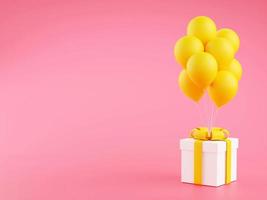Gift box with yellow ribbon and balloons on pink background with copy space. photo