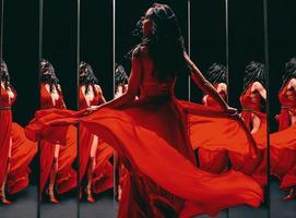 retrato de una hermosa morena con zapatos rojos y vestido dando la vuelta y bailando cerca de los espejos foto