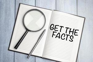 Get the facts word concept on notepad and magnifier photo