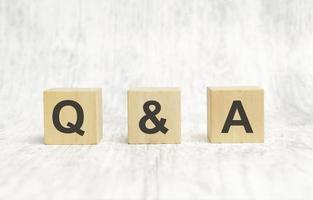 q and a sign on wooden cubes on wooden background photo