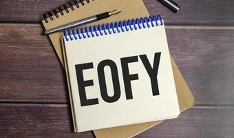 notebook with the word End of Financial Year on wooden background photo